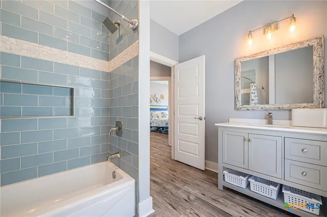 a bathroom with a bathtub a sink a vanity and a shower