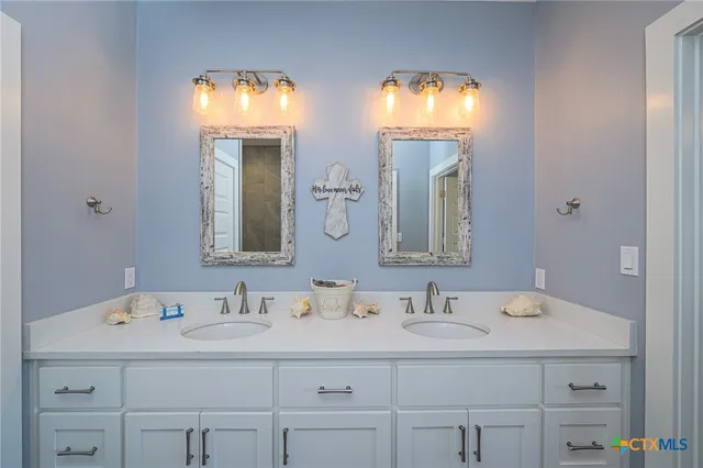 a bathroom with double vanity sink and a mirror