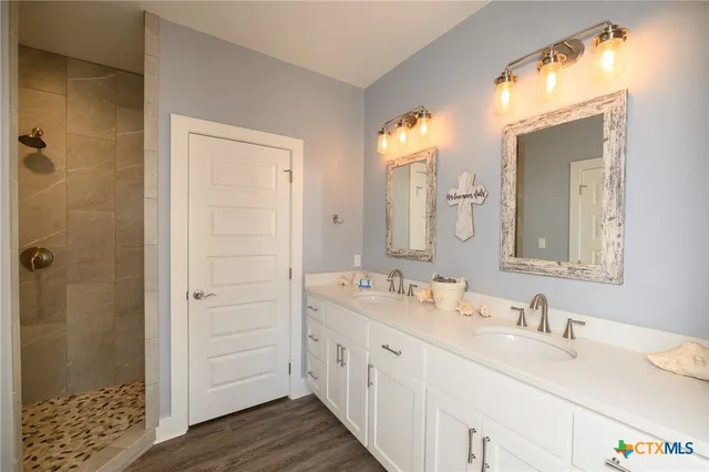 a bathroom with double vanity sinks and a mirror