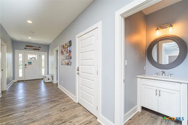 a view of a hallway a closet and wooden floor