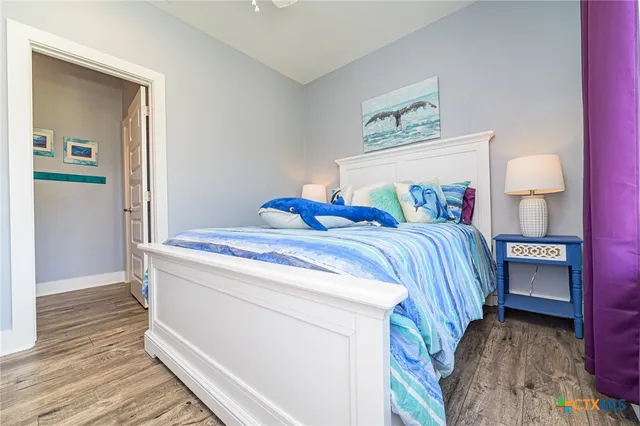 a bedroom with a bed and a lamp on dresser