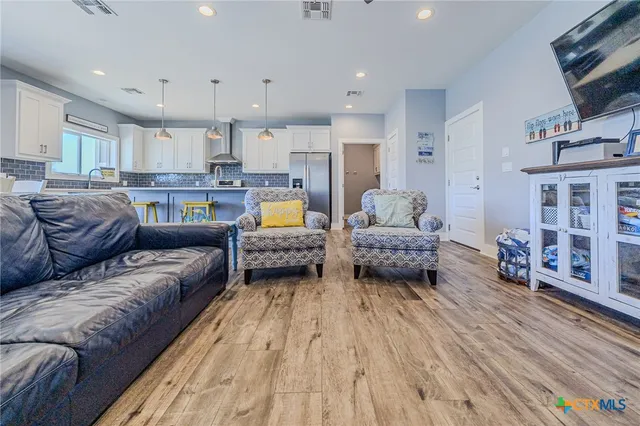 a view of a living room kitchen and a wooden floor