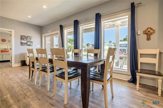a dining room with furniture a chandelier and wooden floor