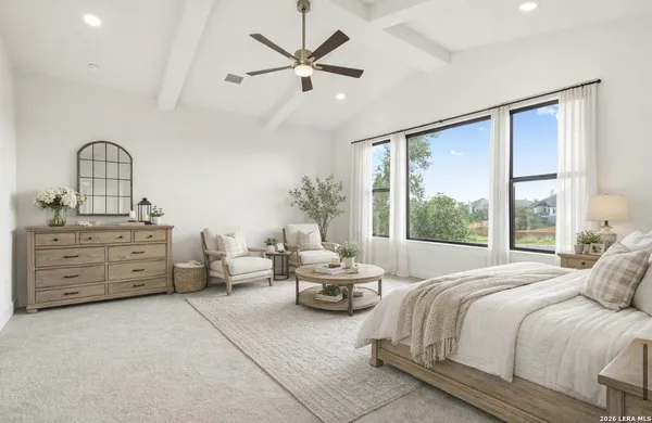 a bedroom with a bed a chandelier and a large window