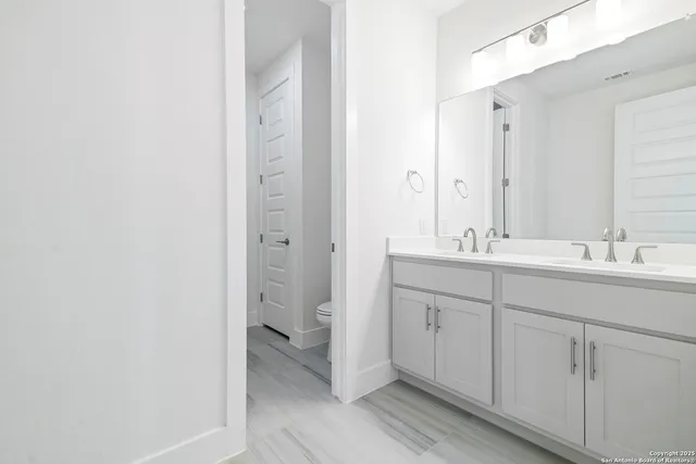 a bathroom with a double vanity sink and mirror