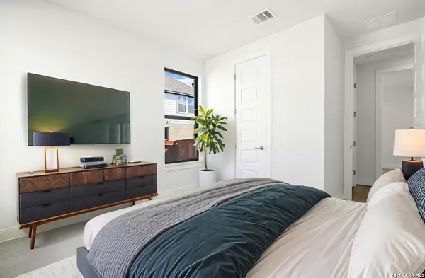 a bedroom with a bed and a flat screen tv