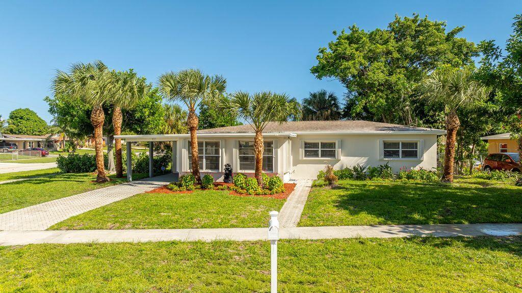 702 South 12th Street Lantana, FL 33462 - Photo 2 of 26 a front view of a house with a yard table and chairs