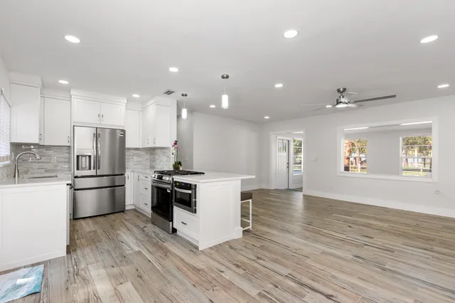 a kitchen with a stove a refrigerator and a dining table