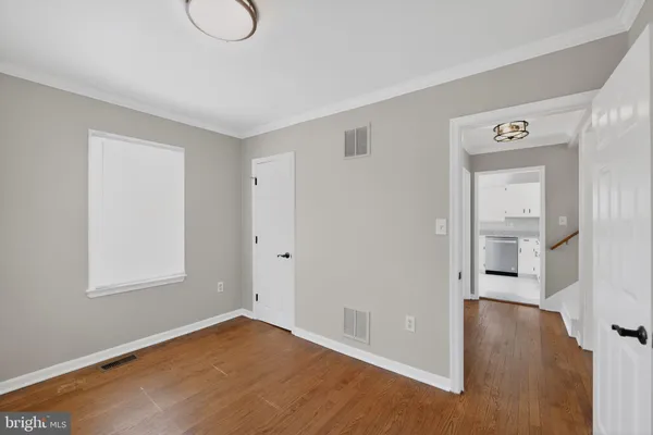an empty room with windows and wooden floor