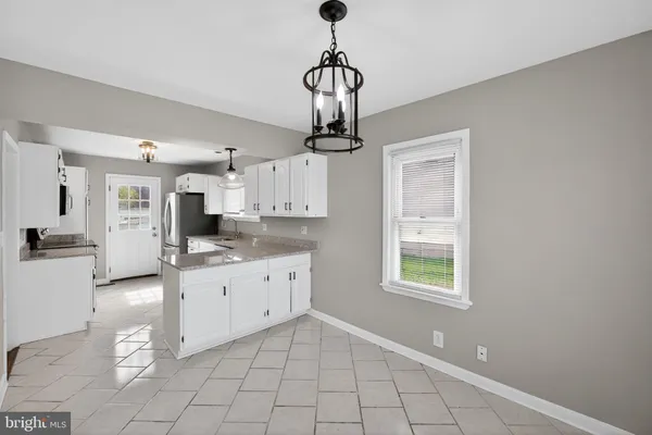 a kitchen with stainless steel appliances granite countertop a sink a stove a refrigerator a counter top space and cabinets
