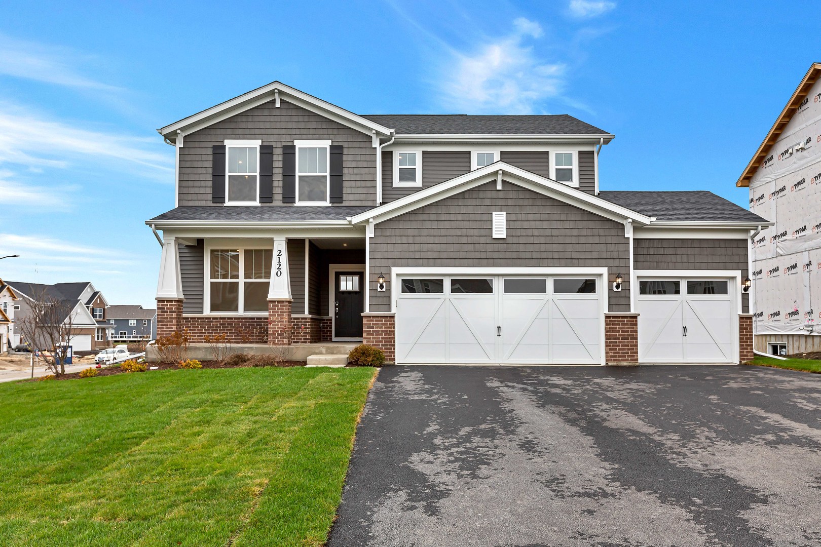 a front view of a house with a yard and trees