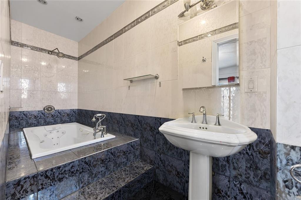 139 86th Street Brooklyn, NY 11209 - Photo 32 of 34 a bathroom with a sink and a mirror