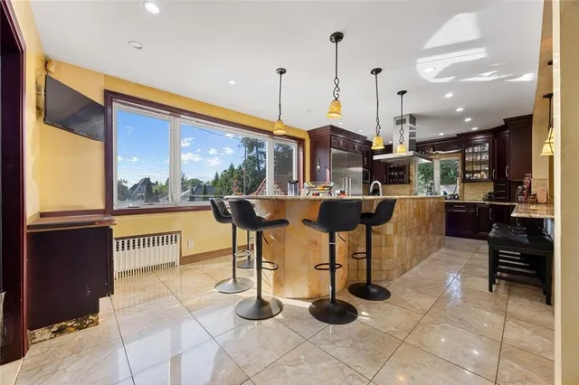 a living room with couches and kitchen view with wooden floor