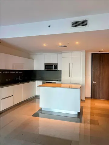 a view of kitchen with stainless steel appliances kitchen island sink and cabinets