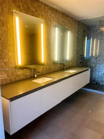 a bathroom with a granite countertop sink and a bathtub