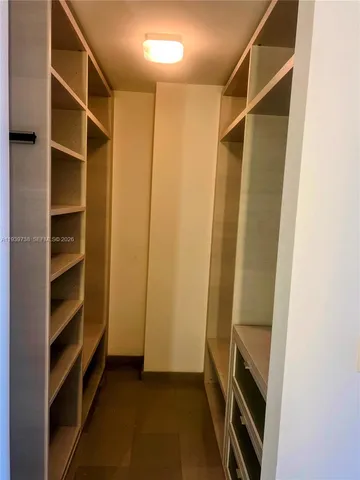 a view of walk in closet with empty racks
