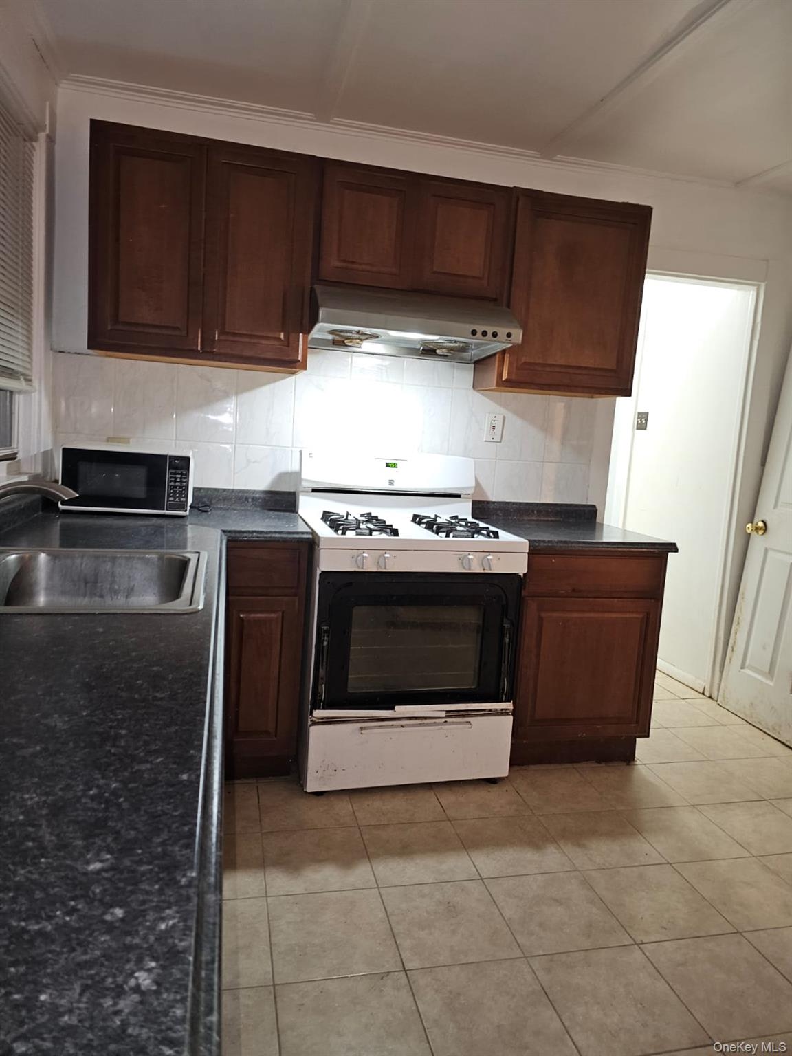 36 Prospect Street Middletown, NY 10940 - Photo 2 of 12 a kitchen with granite countertop a stove top oven microwave and cabinets