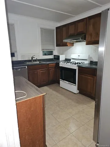 a kitchen with stainless steel appliances granite countertop a stove a refrigerator and a sink