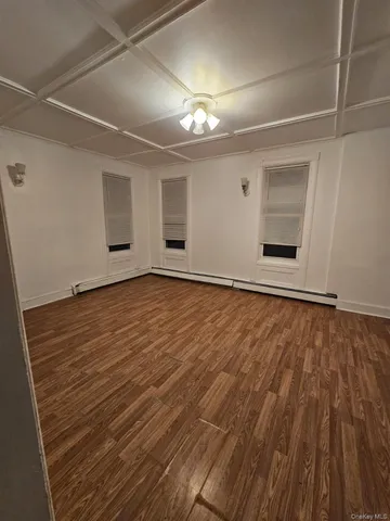 en empty room with wooden floor and window