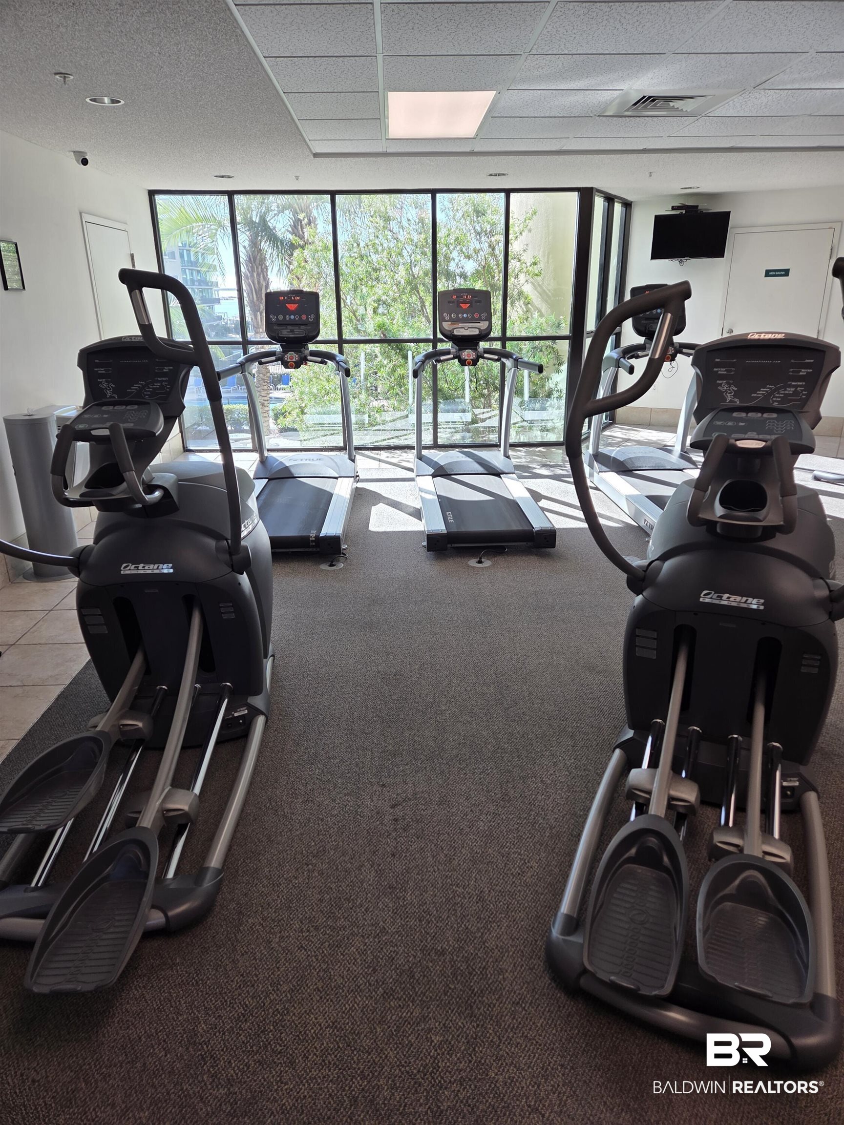 27580 Canal Road, Unit 1210 Orange Beach, AL 36561 - Photo 24 of 28 Gym featuring a wall of windows and a paneled ceiling