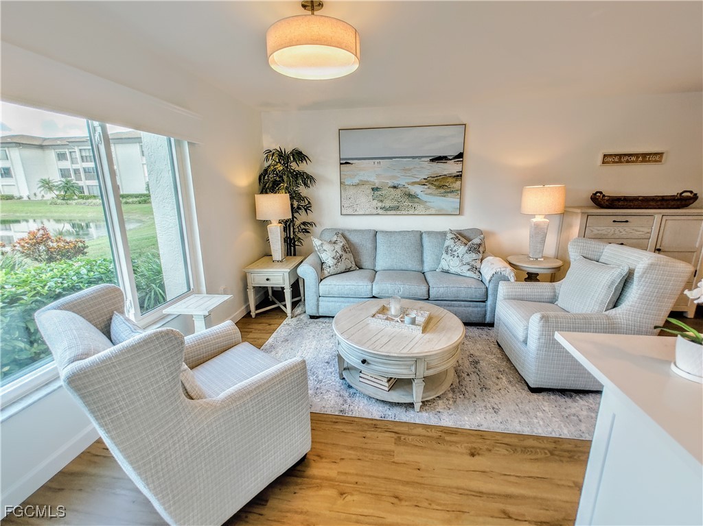 5830 Trailwinds Drive, Unit 813 Fort Myers, FL 33907 - Photo 11 of 39 a living room with furniture and a large window