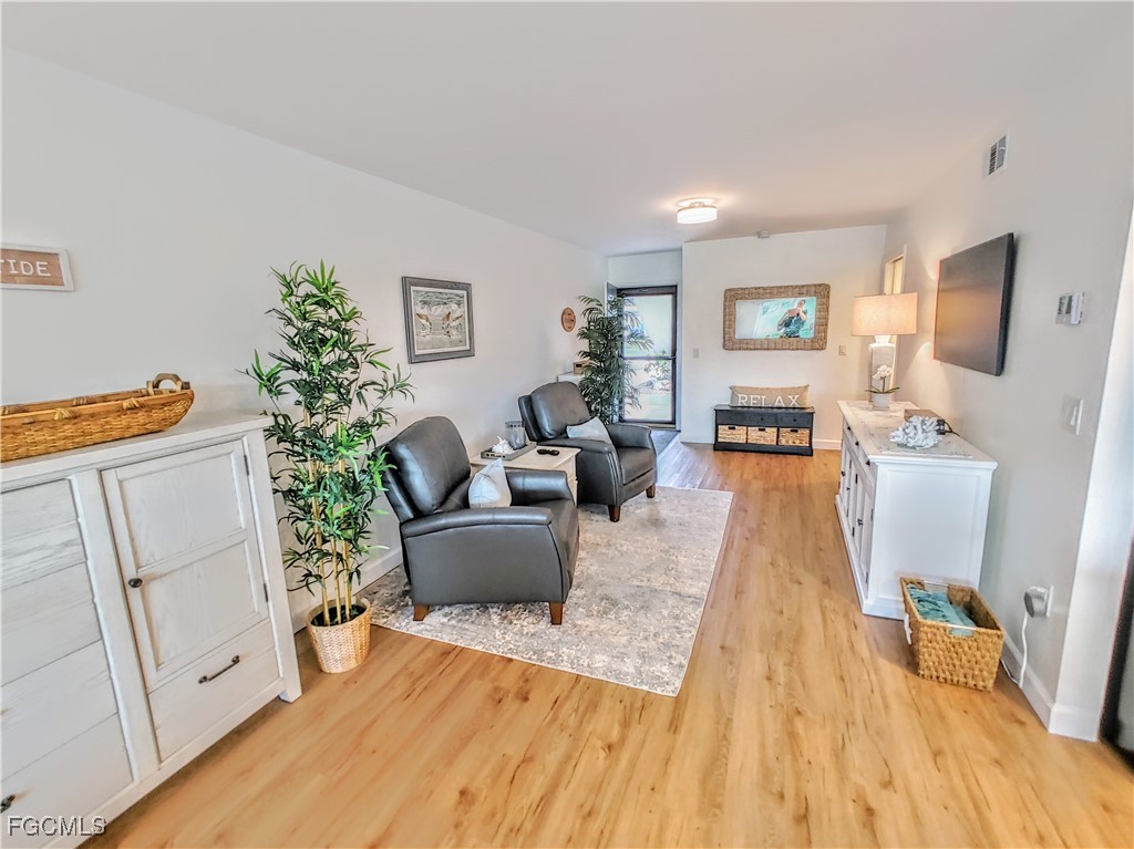 5830 Trailwinds Drive, Unit 813 Fort Myers, FL 33907 - Photo 12 of 39 a living room with furniture and a flat screen tv