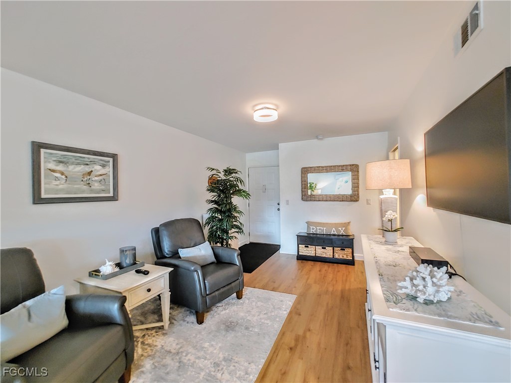 5830 Trailwinds Drive, Unit 813 Fort Myers, FL 33907 - Photo 15 of 39 a living room with furniture and wooden floor