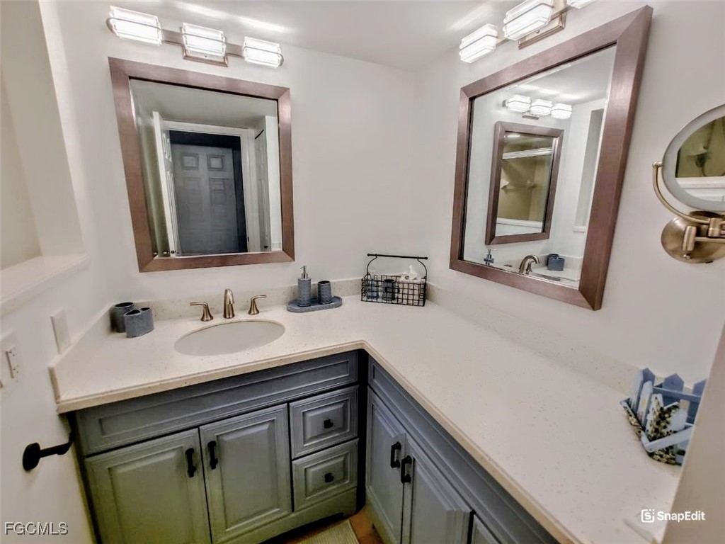 5830 Trailwinds Drive, Unit 813 Fort Myers, FL 33907 - Photo 18 of 39 a bathroom with a sink vanity and mirror