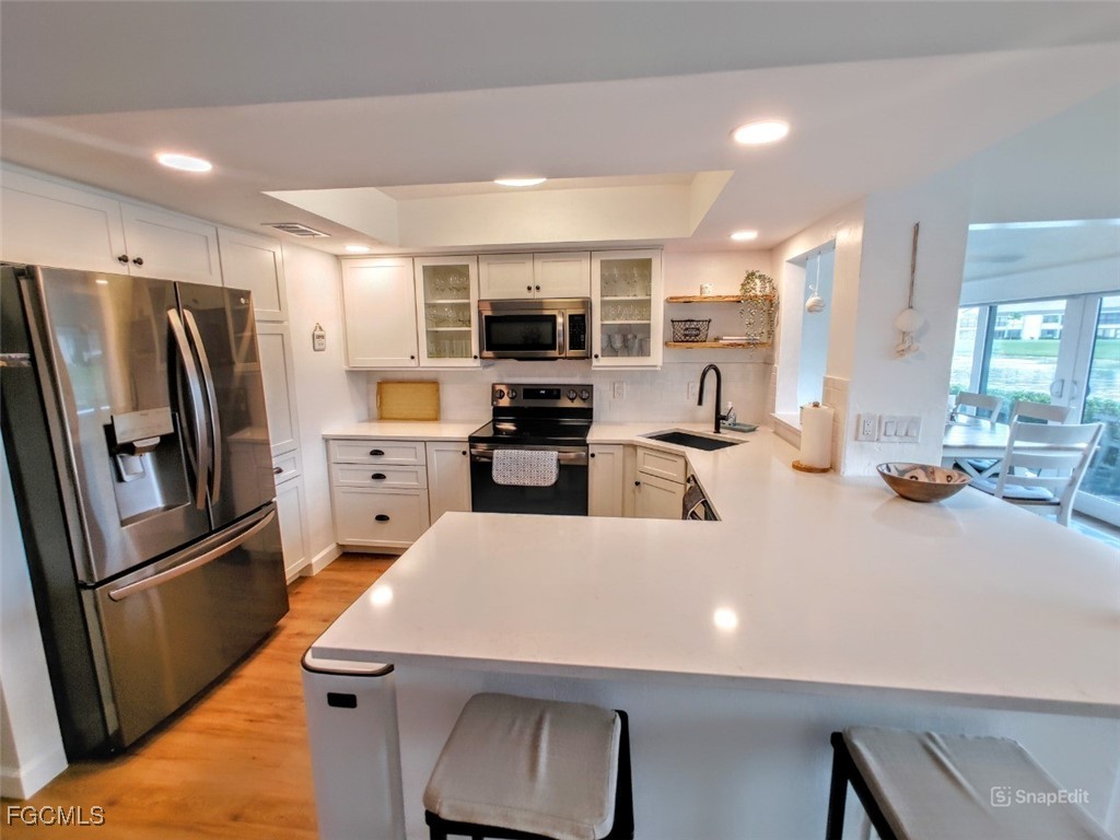 5830 Trailwinds Drive, Unit 813 Fort Myers, FL 33907 - Photo 2 of 39 a kitchen with stainless steel appliances a refrigerator and a stove top oven