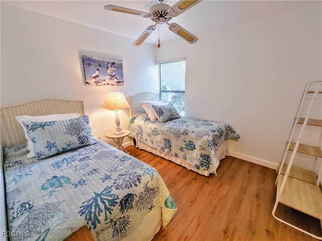 5830 Trailwinds Drive, Unit 813 Fort Myers, FL 33907 - Photo 21 of 39 a bedroom with two beds and a chandelier