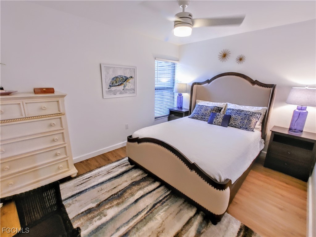 5830 Trailwinds Drive, Unit 813 Fort Myers, FL 33907 - Photo 22 of 39 a bedroom with a bed and wooden floor