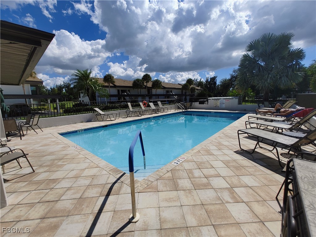 5830 Trailwinds Drive, Unit 813 Fort Myers, FL 33907 - Photo 29 of 39 a view of a swimming pool with lounge chairs