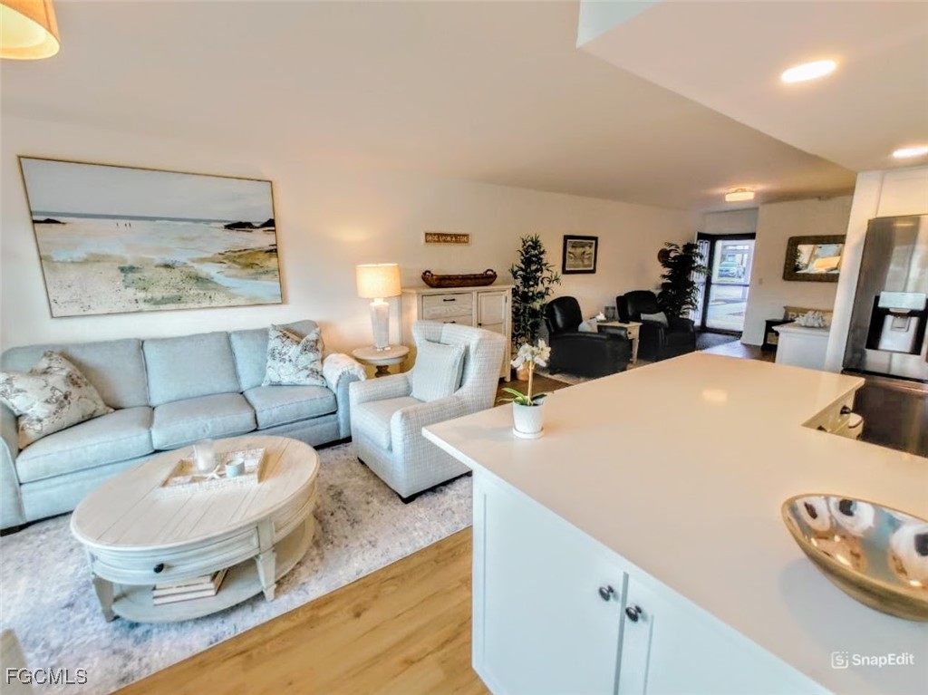 5830 Trailwinds Drive, Unit 813 Fort Myers, FL 33907 - Photo 3 of 39 a living room with furniture and a wooden floor