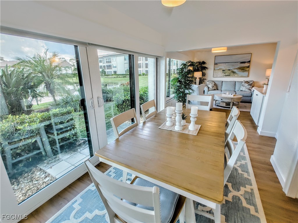 5830 Trailwinds Drive, Unit 813 Fort Myers, FL 33907 - Photo 5 of 39 a view of a dining room with furniture window and wooden floor