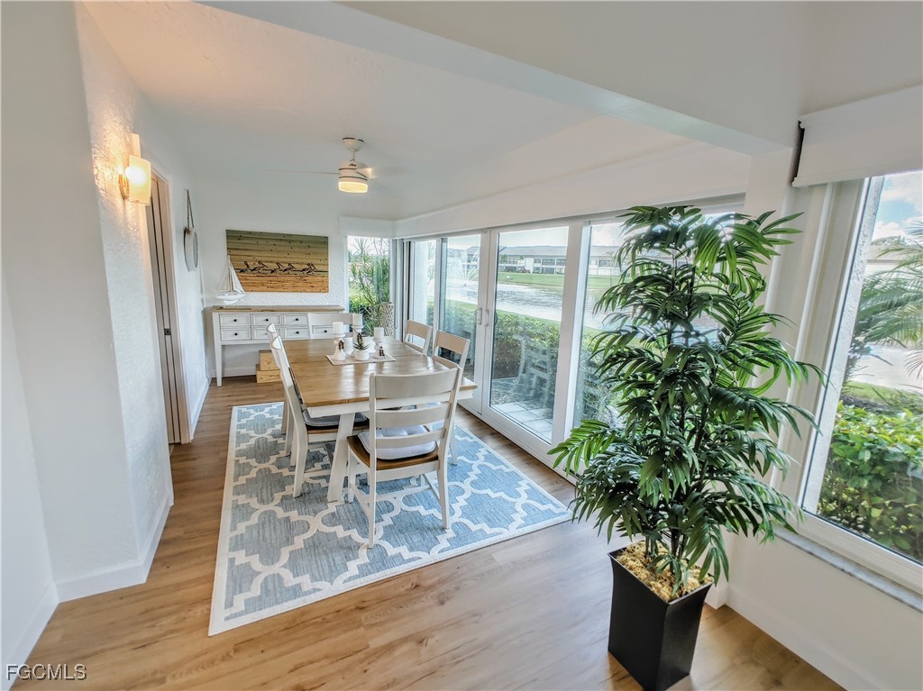 5830 Trailwinds Drive, Unit 813 Fort Myers, FL 33907 - Photo 7 of 39 a dining room with furniture potted plants and wooden floor