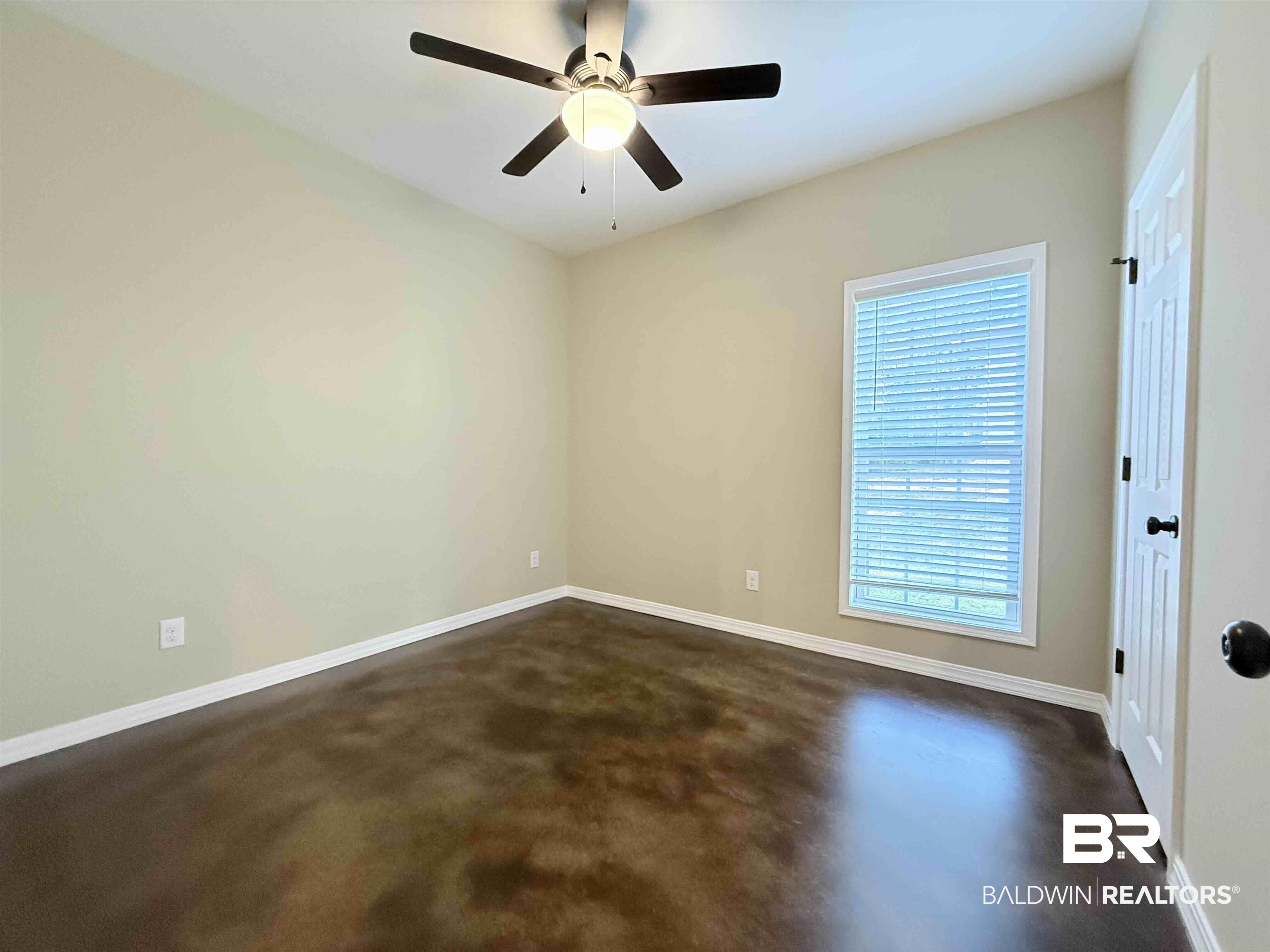 33071 -B Stables Drive, Unit B Daphne, AL 36527 - Photo 7 of 13 Empty room with finished concrete floors and a ceiling fan