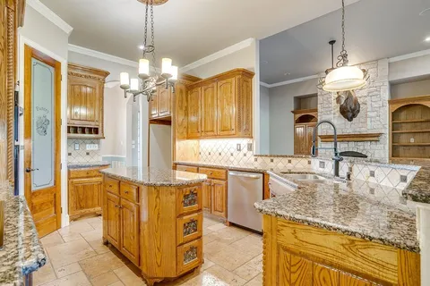 a kitchen with granite countertop a sink stove and refrigerator