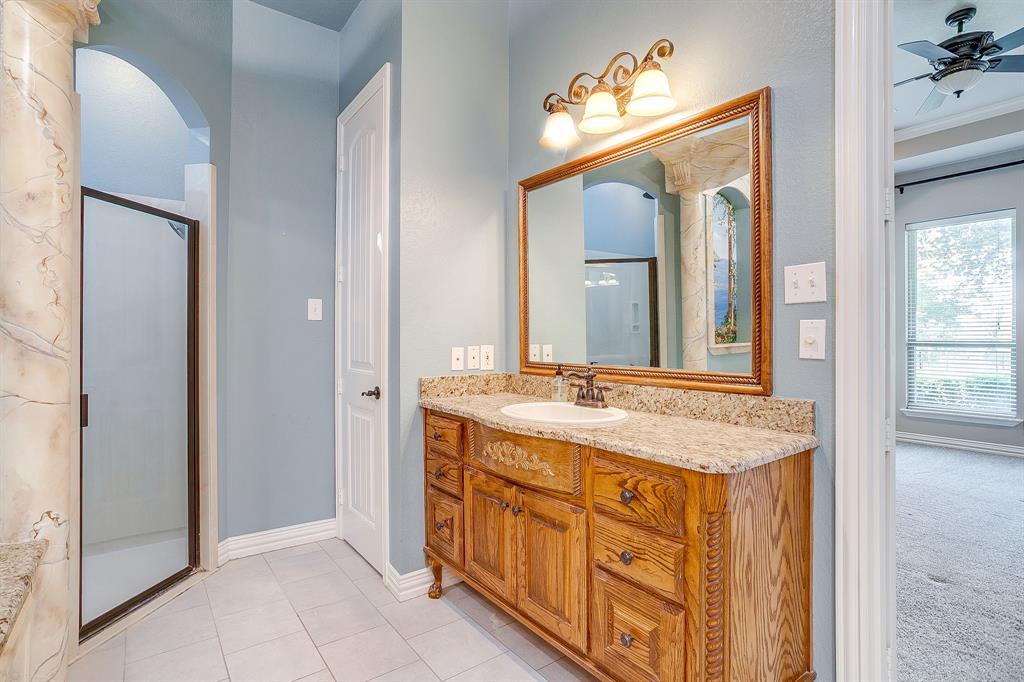 9549 Dickson Road Fort Worth, TX 76179 - Photo 24 of 40 a bathroom with a granite countertop sink a mirror and a vanity