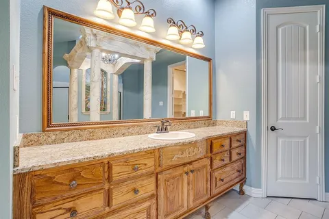 a bathroom with a granite countertop sink and a mirror