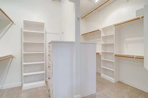 a view of walk in closet with empty racks