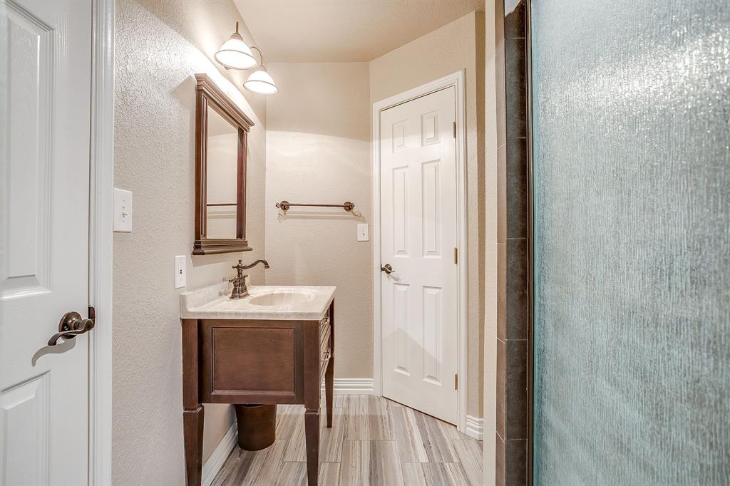 9549 Dickson Road Fort Worth, TX 76179 - Photo 29 of 40 a bathroom with a sink a mirror a vanity and a toilet