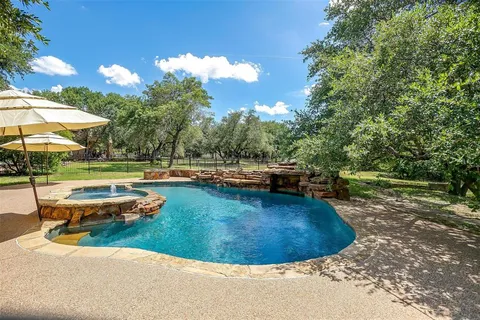 a view of a swimming pool with a yard and sitting area