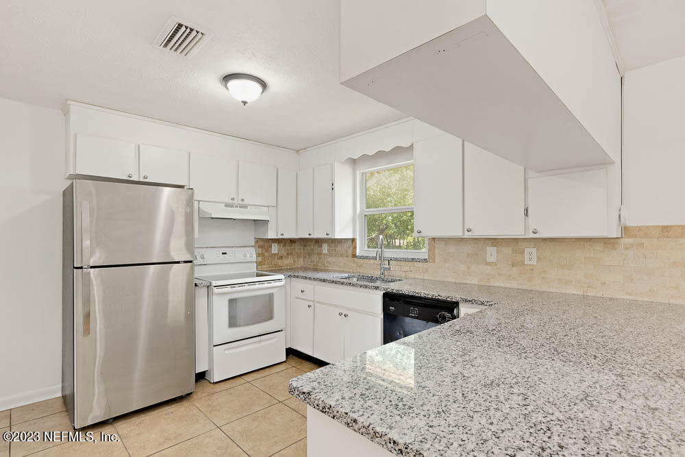 10571 Villanova Road Jacksonville, FL 32218 - Photo 6 of 21 a kitchen with white cabinets and white appliances
