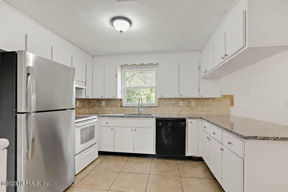10571 Villanova Road Jacksonville, FL 32218 - Photo 7 of 21 a kitchen with white cabinets and white appliances