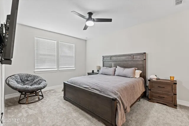 a bedroom with a bed tv and a window