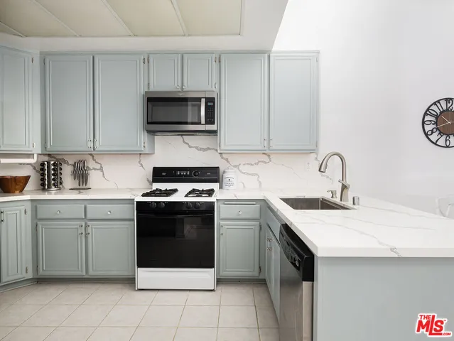 a kitchen with a sink appliances and cabinets