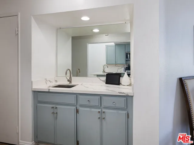 a bathroom with a granite countertop sink and a mirror