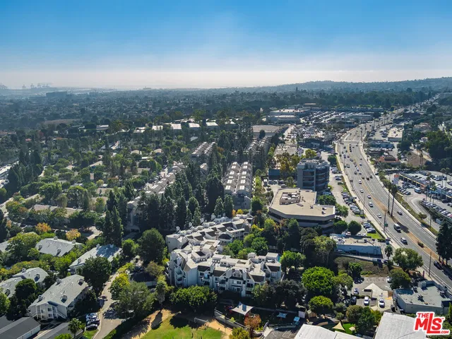 an aerial view of residential house with outdoor space and trees all around