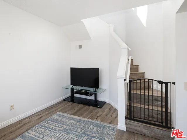 a view of a livingroom with wooden floor and a flat screen tv