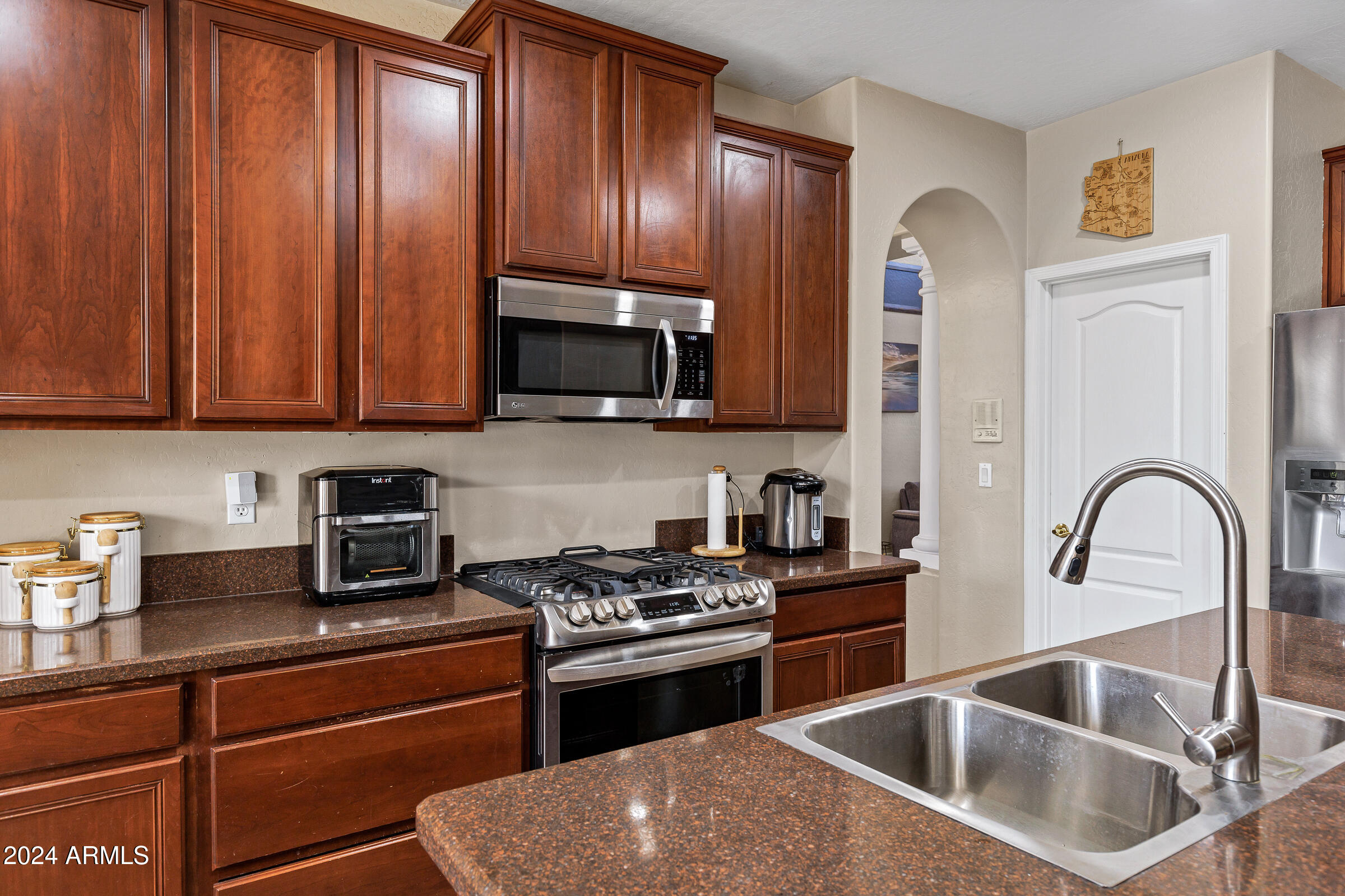 2801 West Silver Fox Way Phoenix, AZ 85045 - Photo 16 of 76 a kitchen with granite countertop a sink stainless steel appliances and cabinets